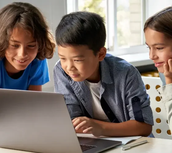Crianças acompanhando uma aula de inglês pelo notebook